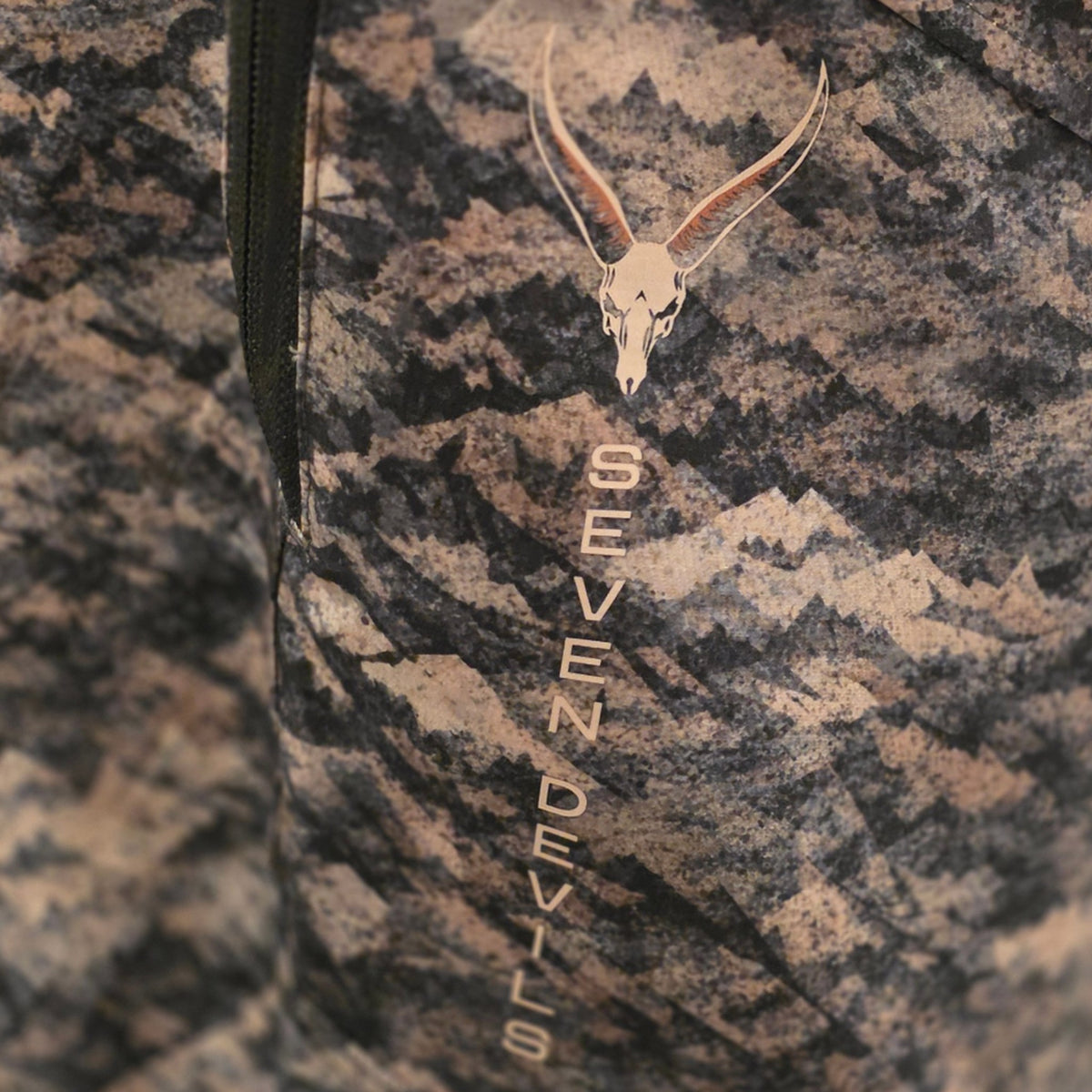 Close-up of the Seven Devils skull logo and vertical wordmark on the thigh of the Grave Point Pant